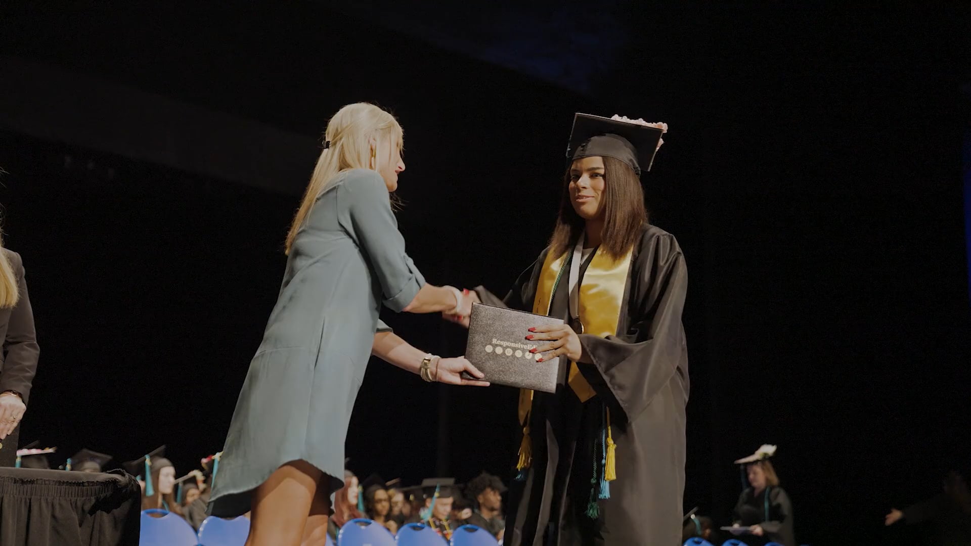 female receiving diploma on stage