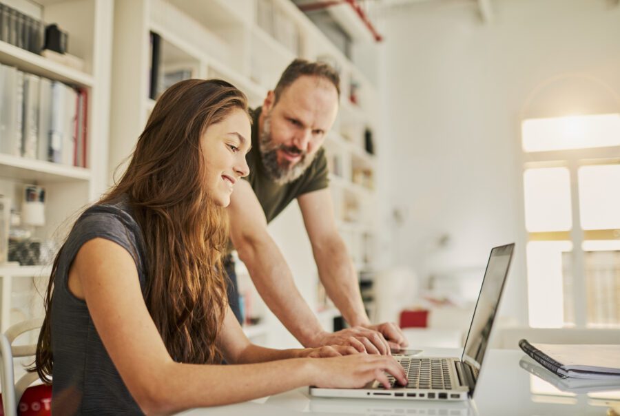 Single father helping teenager with her homework.